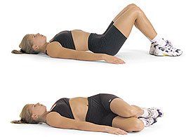 A woman is laying on her stomach on the floor doing a exercise.