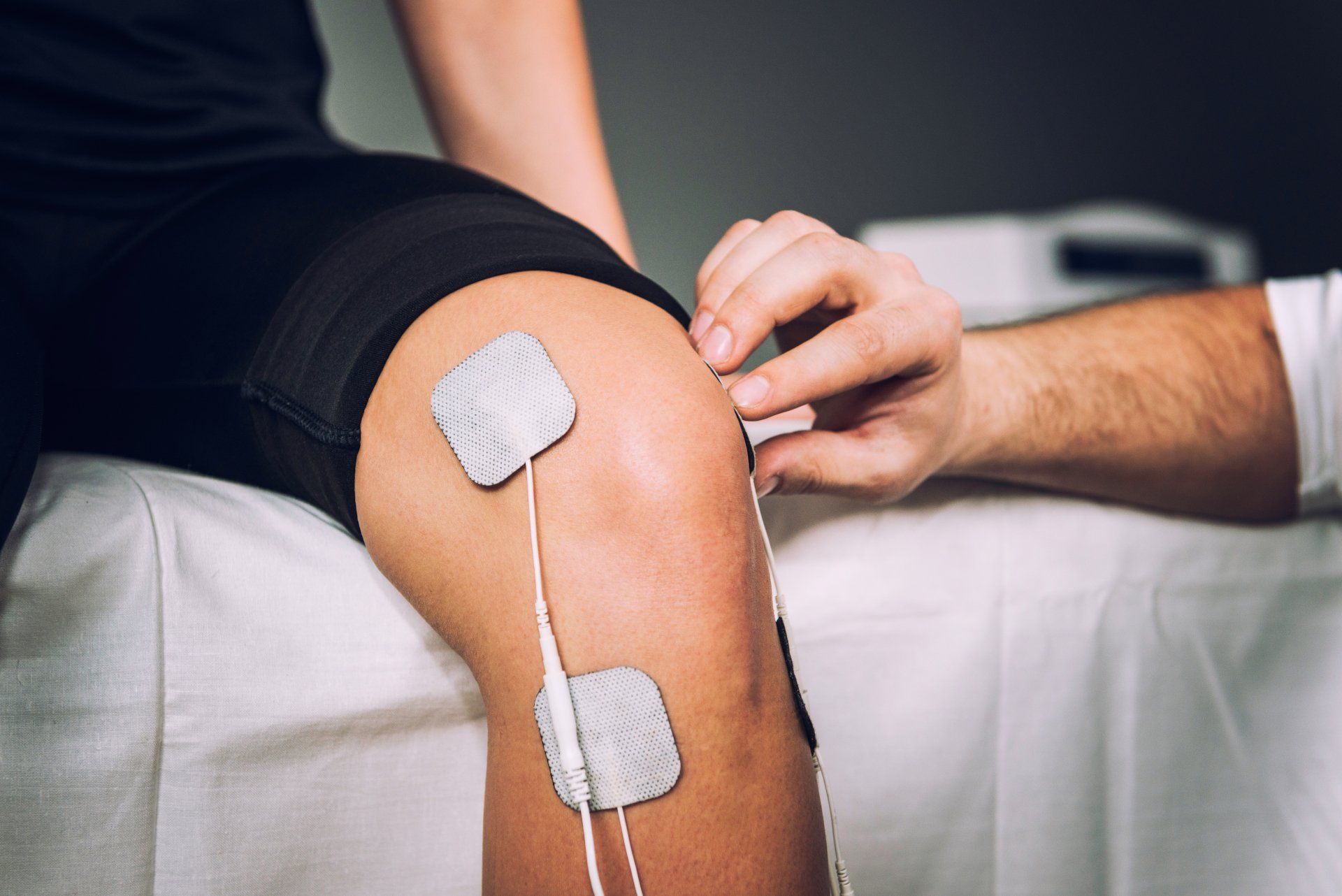 A person is getting electrodes on their knee.