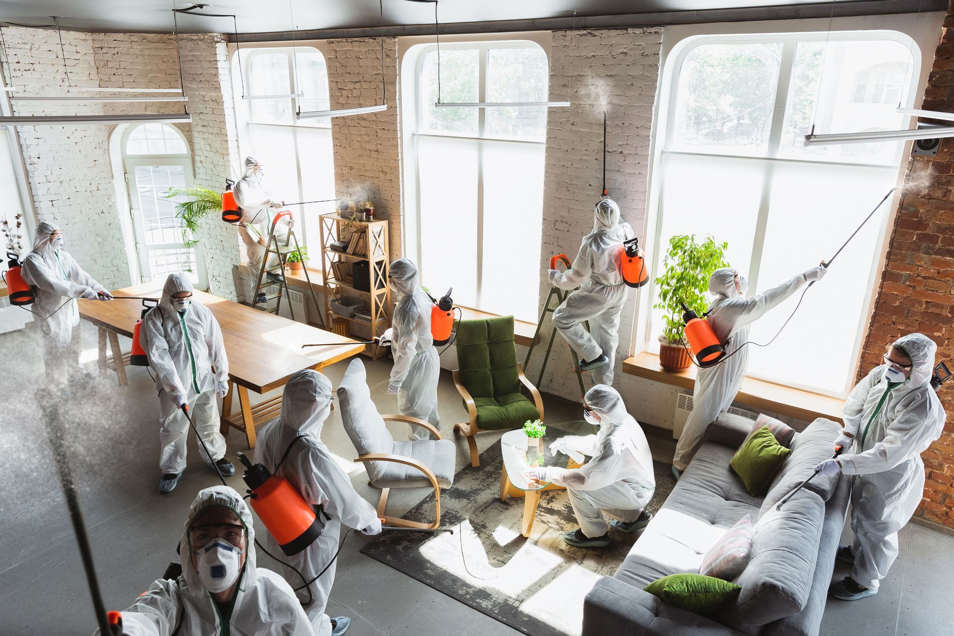 A group of people in protective suits are disinfecting an office.