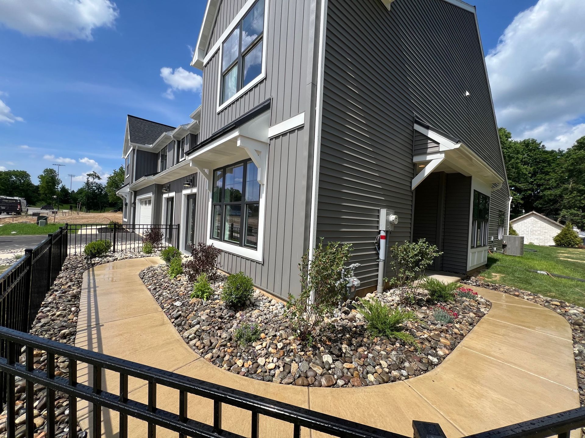 A house with a walkway leading to it and a fence around it.