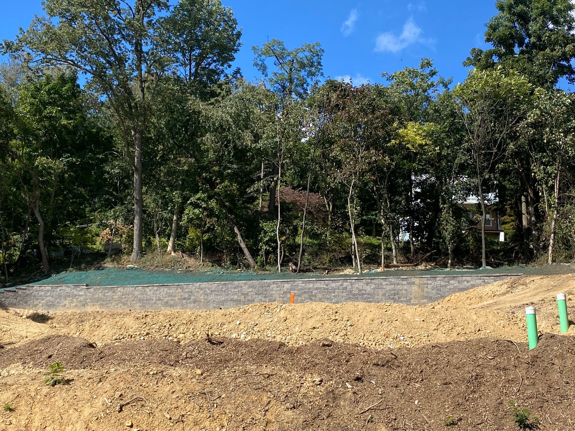 A dirt field with trees in the background on a sunny day by complete property solutions of Lancaster PA