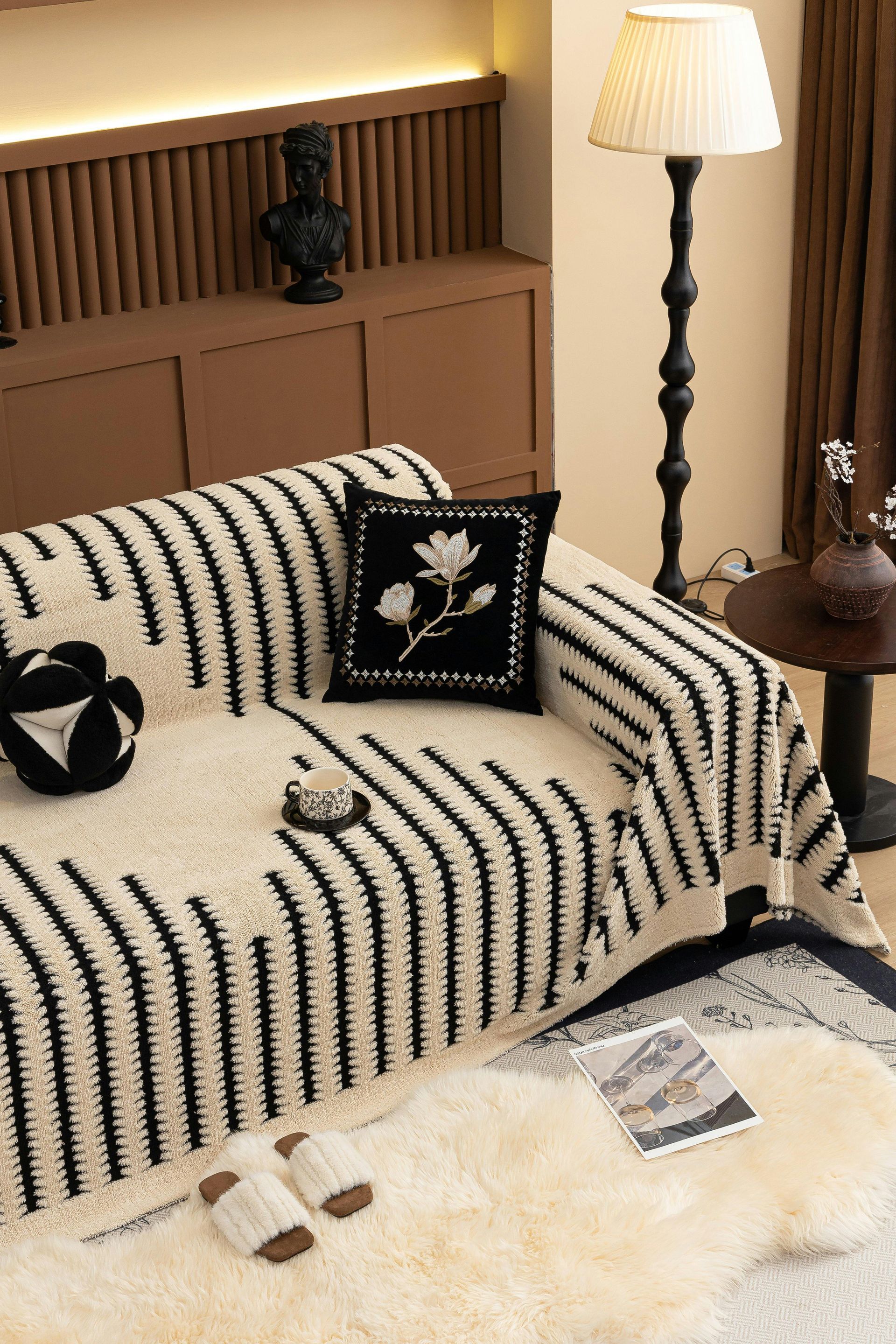 A black and white striped blanket is on a couch in a living room.