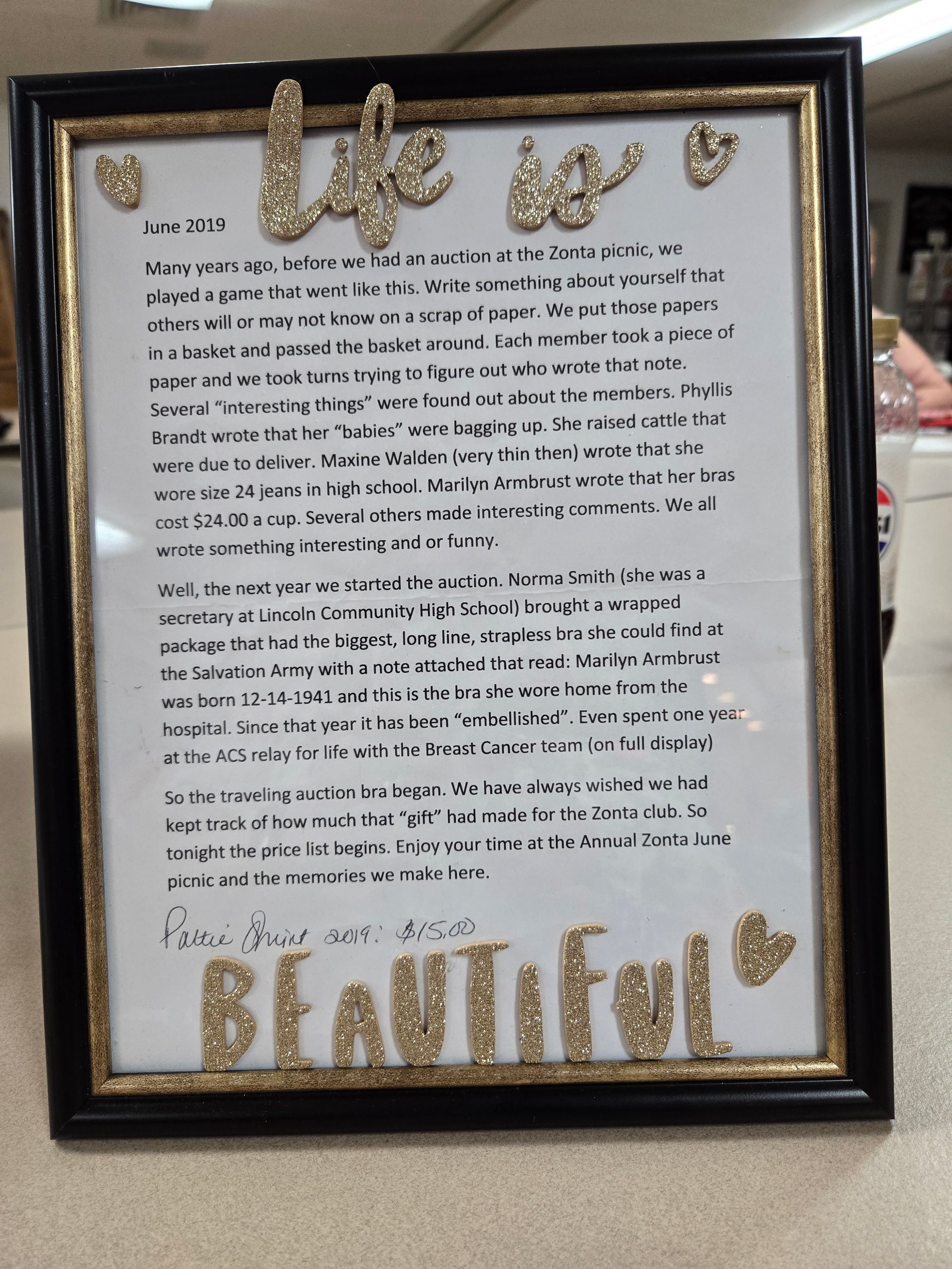 Framed artwork: black frame, gold trim, text 