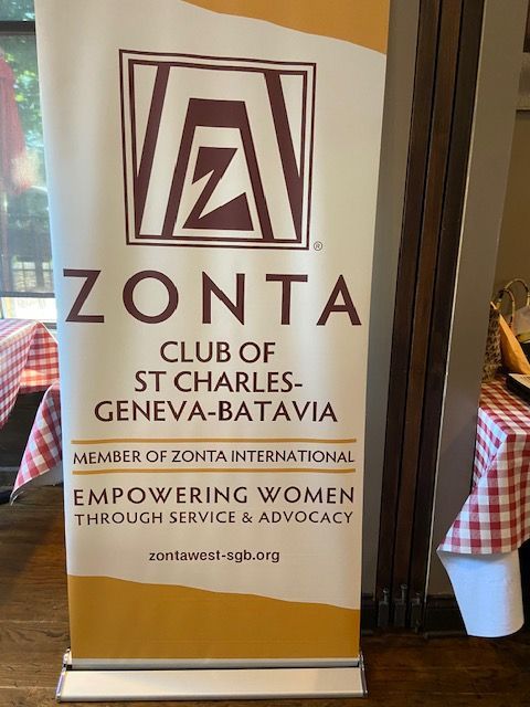 Banner for Zonta Club of St. Charles-Geneva-Batavia. Brown logo and text on a beige background; 