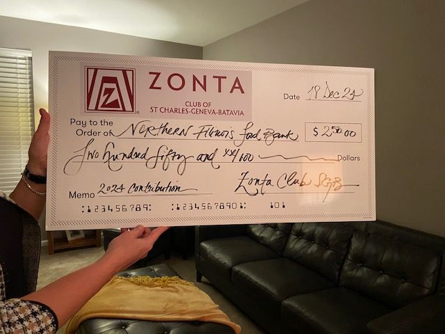 Person holding a large check from Zonta Club, made out to 