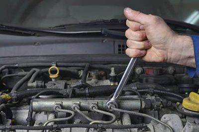 Hand of auto mechanic with a wrench