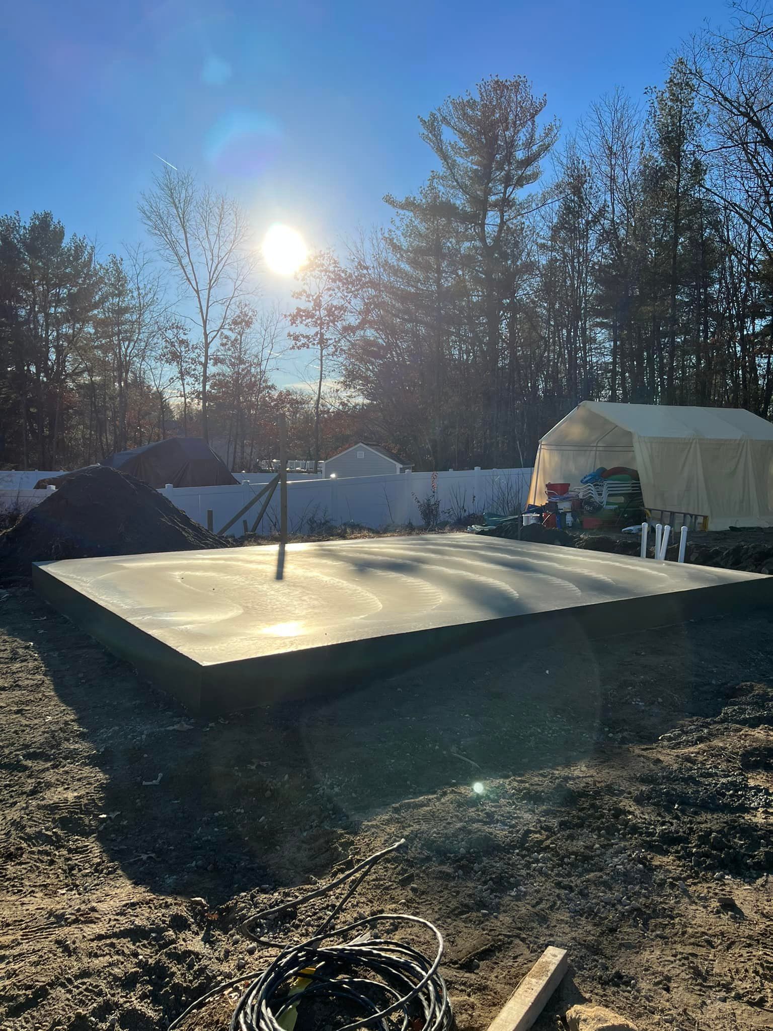 A large concrete slab is sitting in the middle of a dirt field.