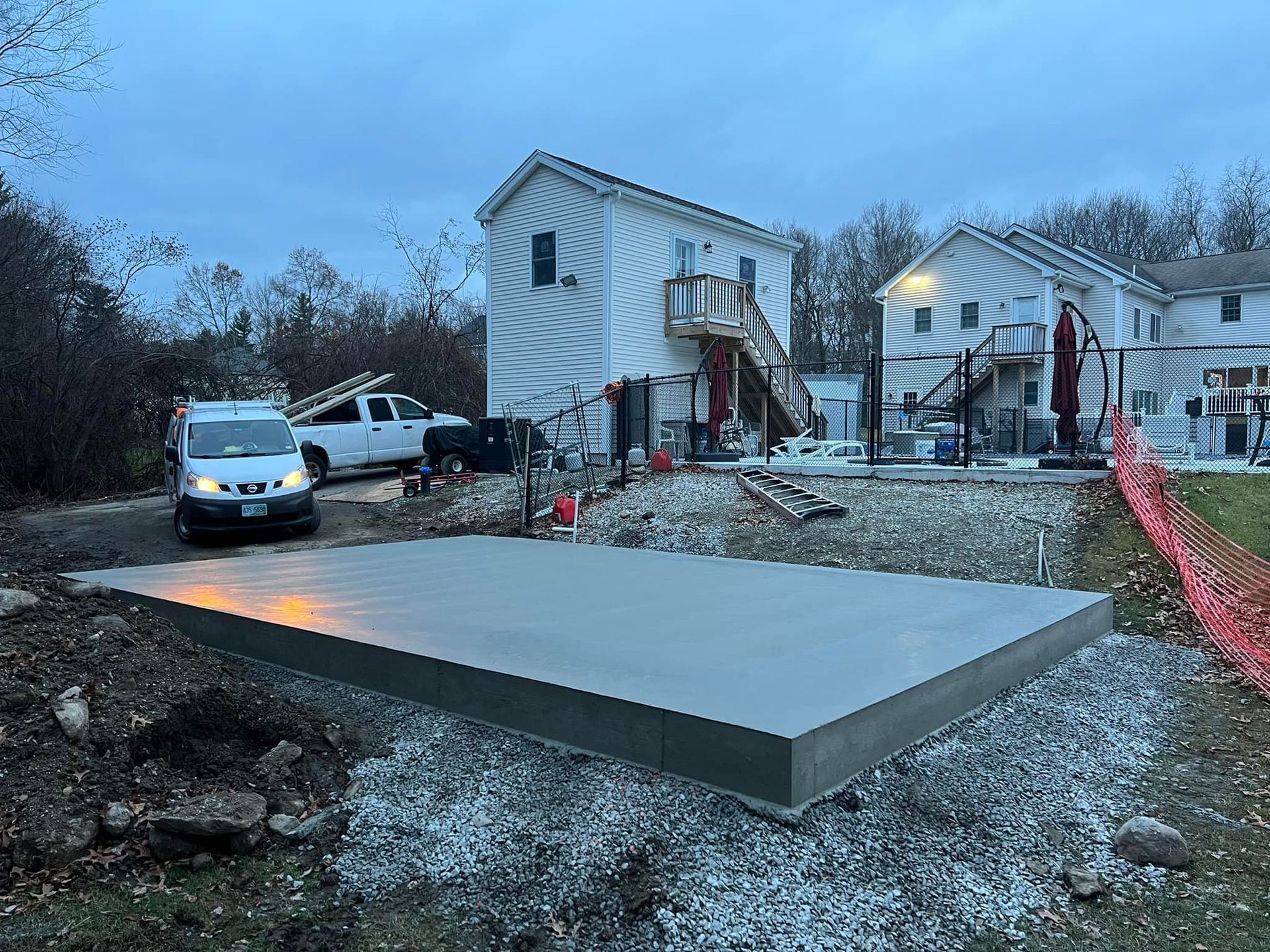 A white van is parked in front of a house under construction.