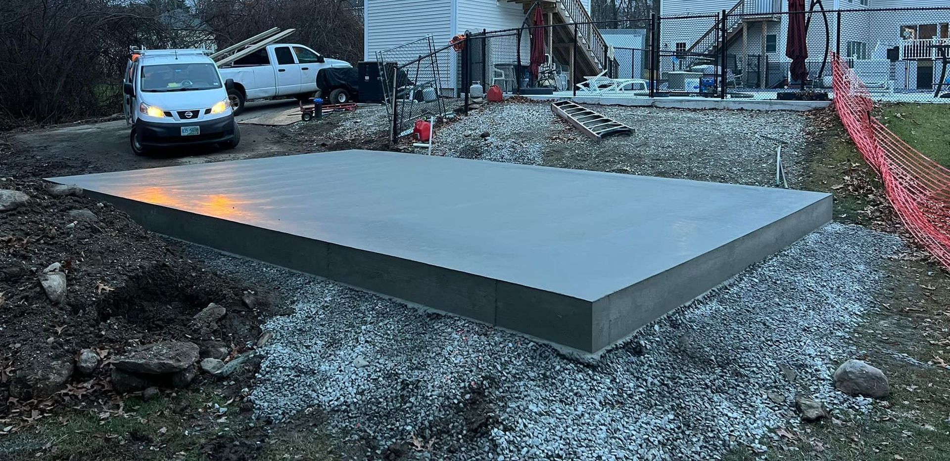 A white truck is parked next to a large concrete slab.