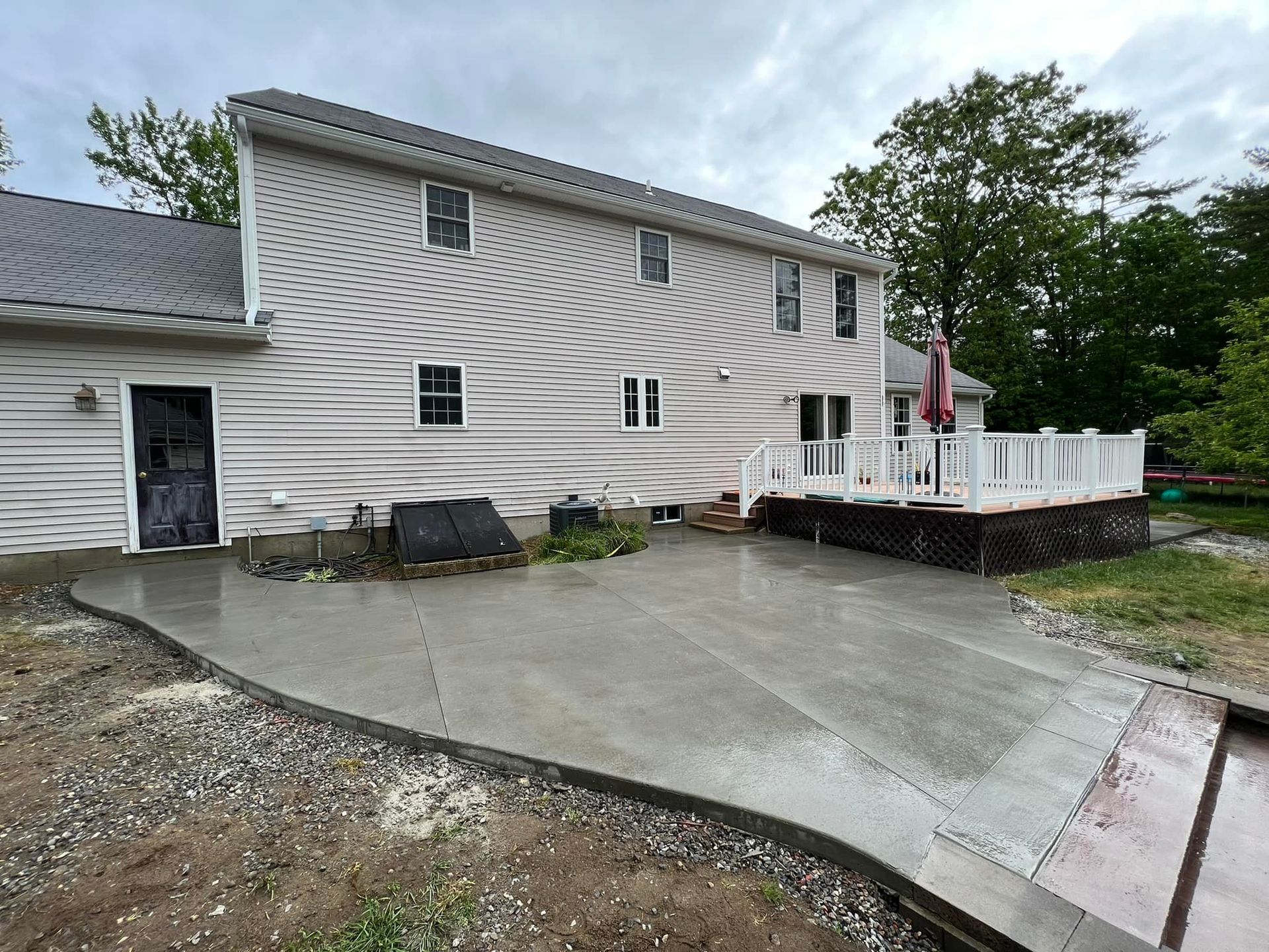 A large white house with a concrete patio in front of it.