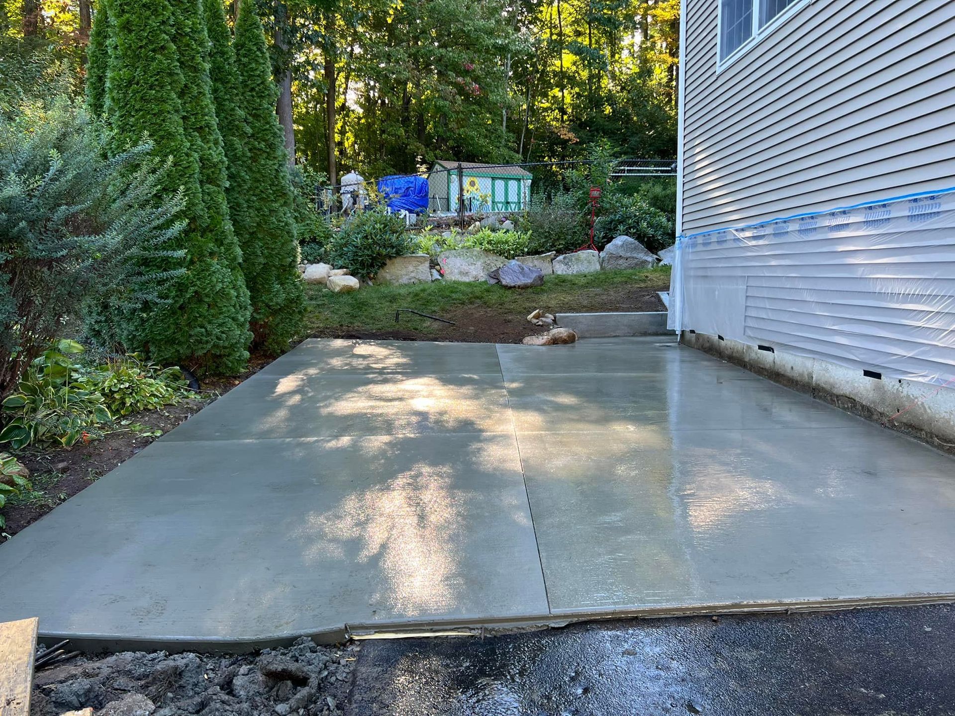 A concrete driveway is being built in front of a house.