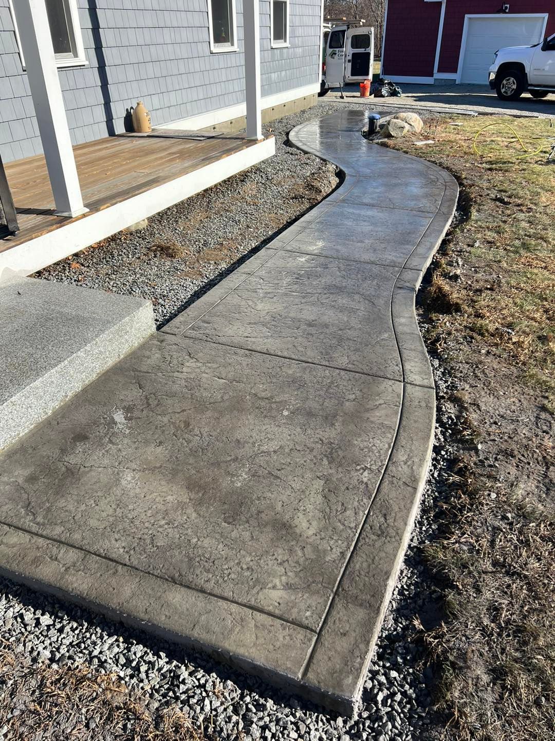 A concrete walkway is being built in front of a house.