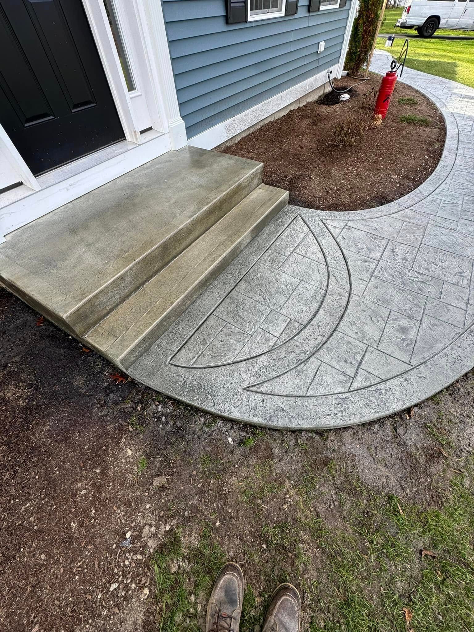 A person is standing on a sidewalk in front of a house.