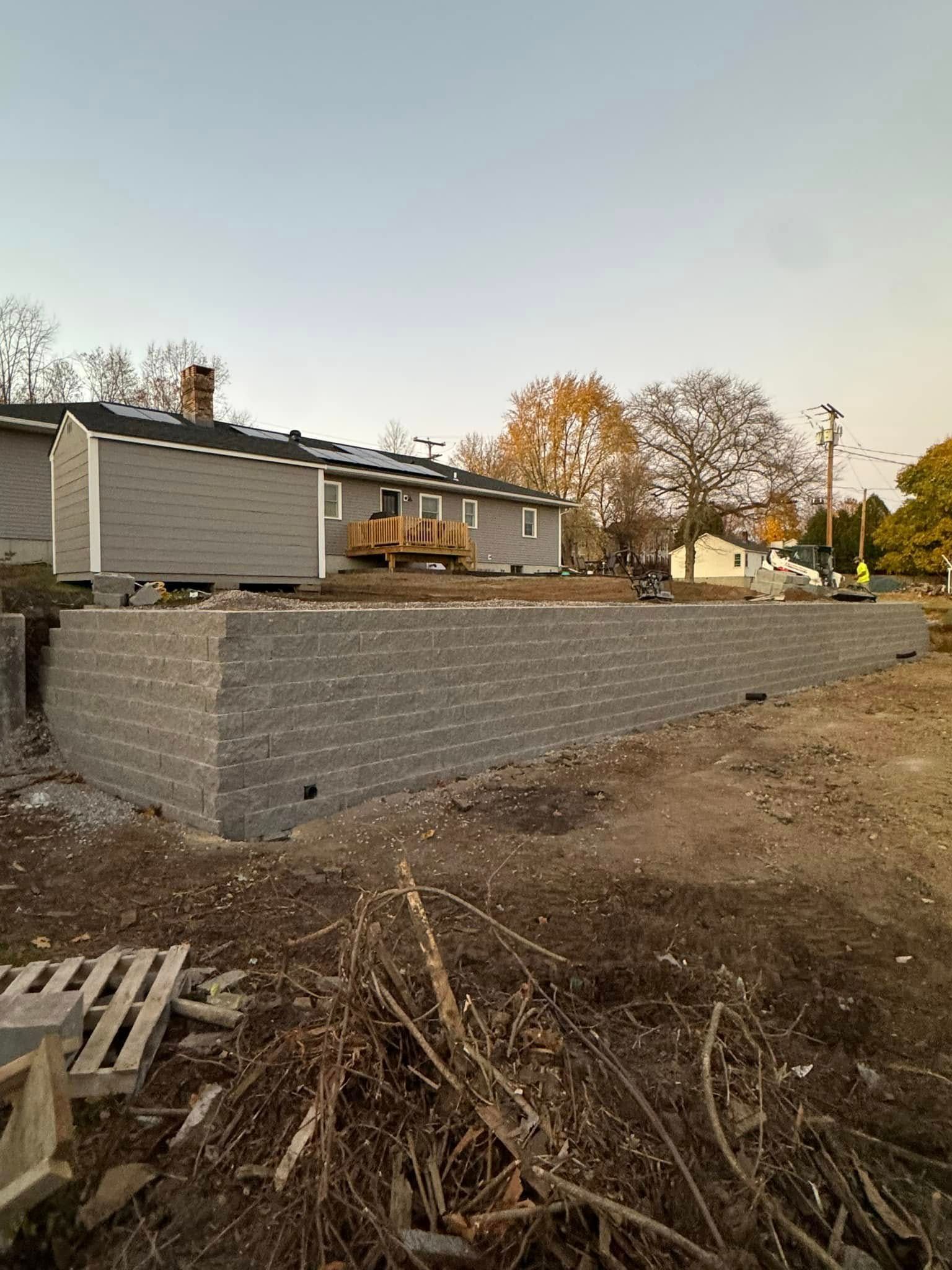 A brick wall is being built in front of a house.