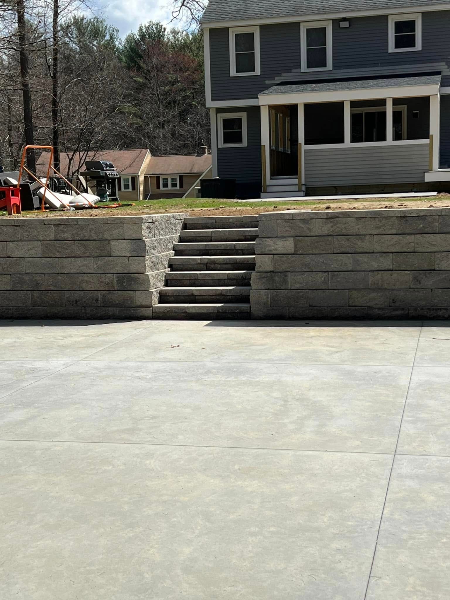 A concrete driveway with stairs leading up to a house
