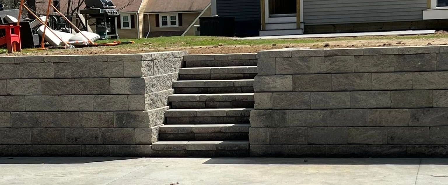 A brick wall with stairs leading up to a house