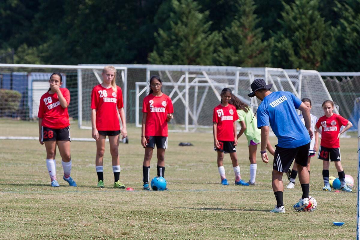Soccer coach instructing a team of players at the United Futbol Academy Elite Camp