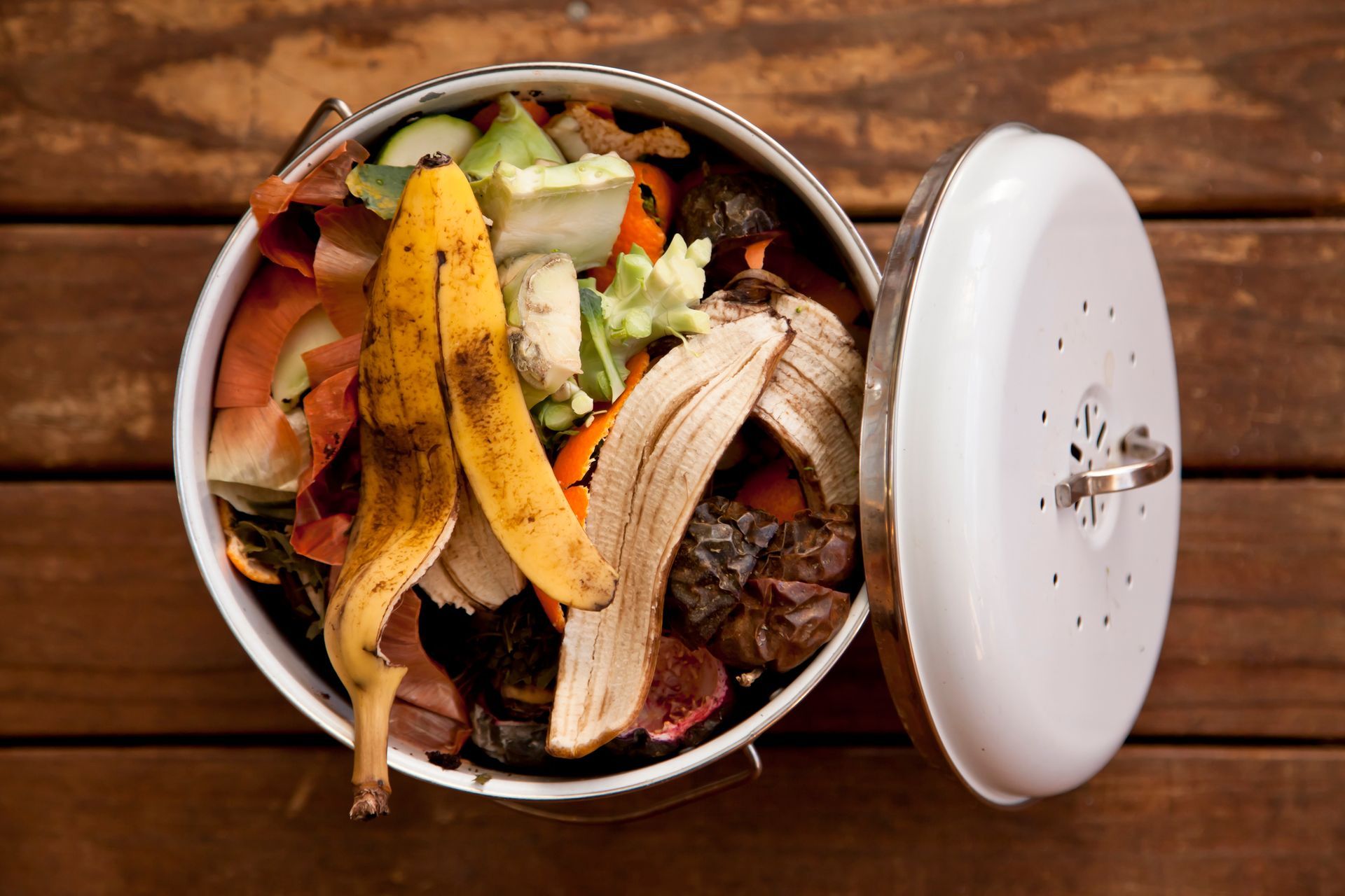 A White Trash Can Filled with Food Scraps on A Wooden Table | Caboolture, QLD | Dumpit Handy Bins
