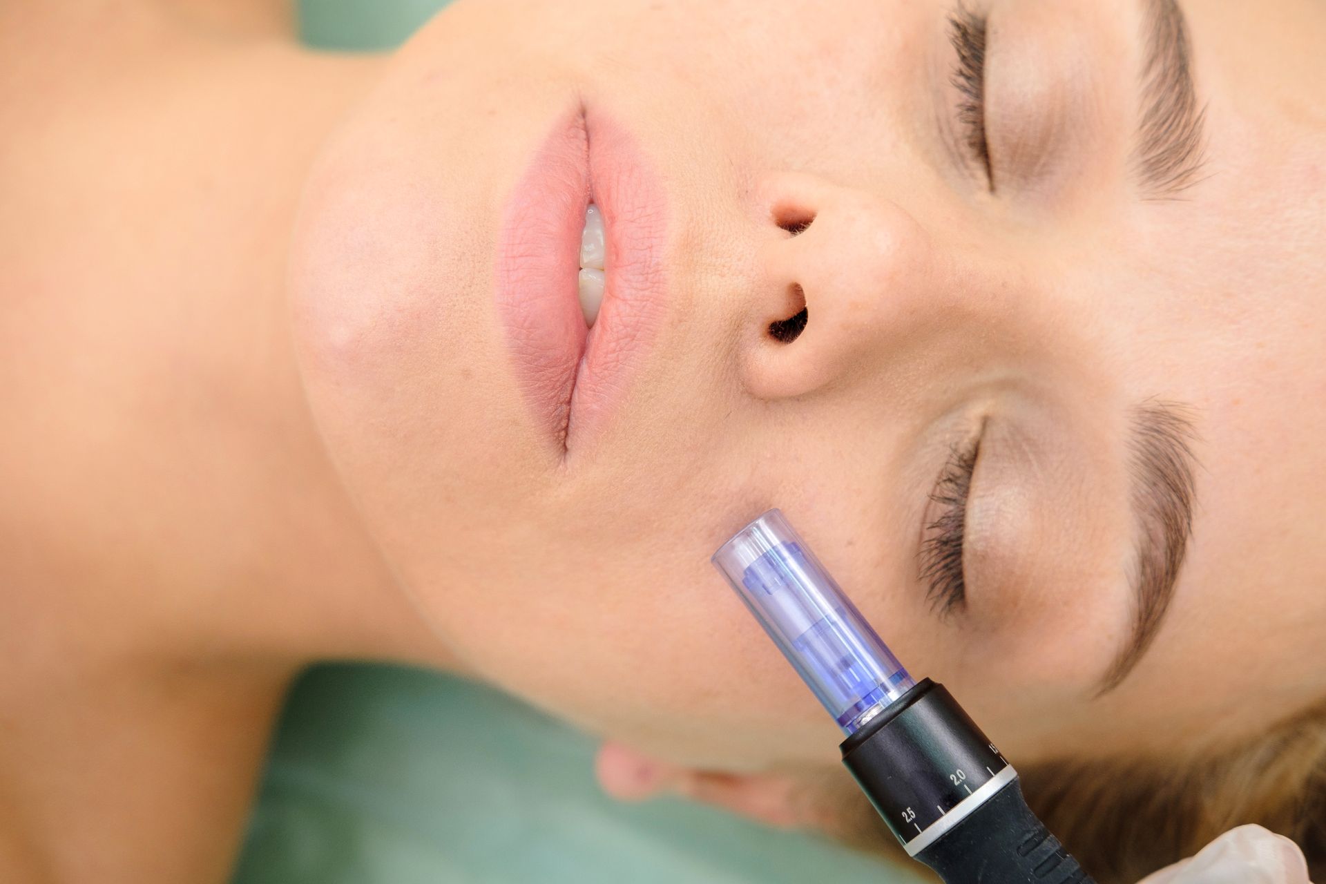 A woman is getting a facial treatment with a machine on her face.