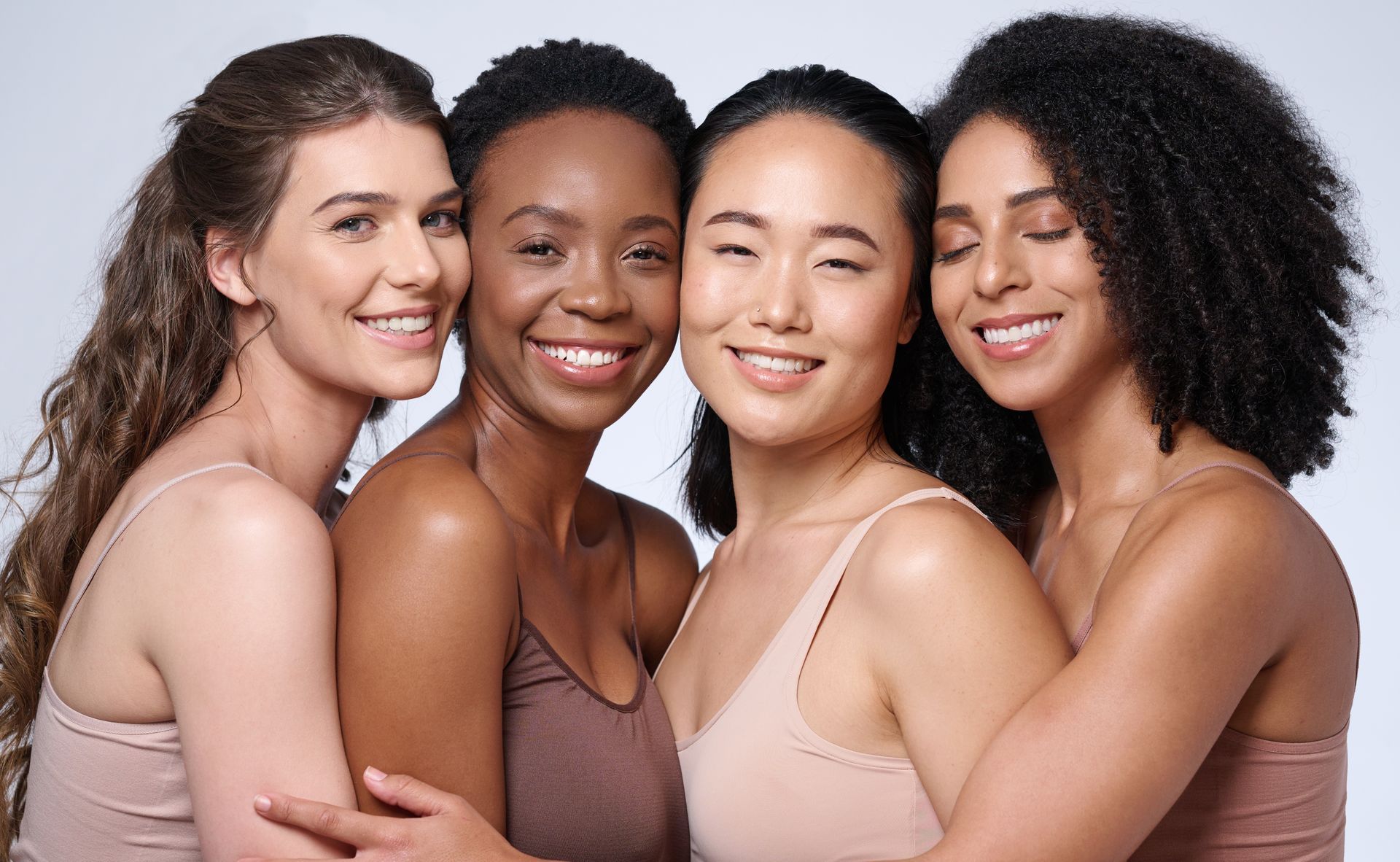 A group of women of different races are posing for a picture together.