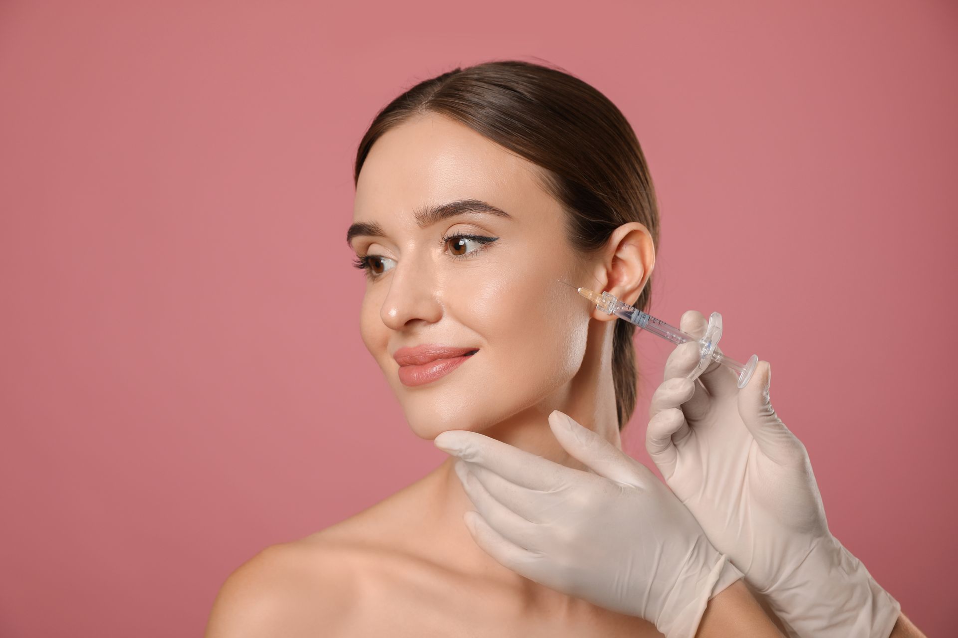 a woman is getting a botox injection in her face .