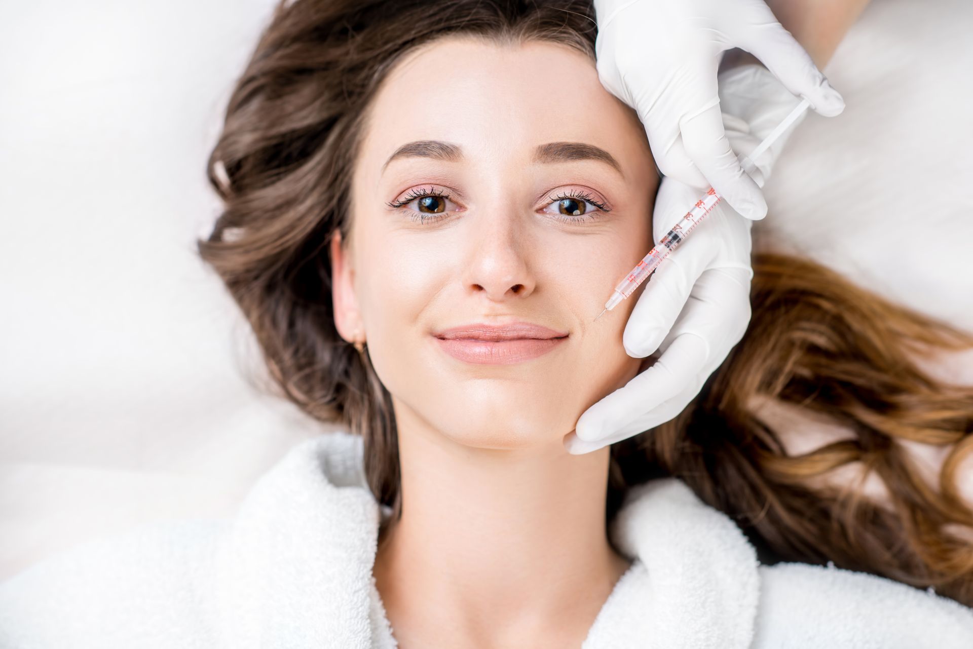 A woman is getting a botox injection in her face.