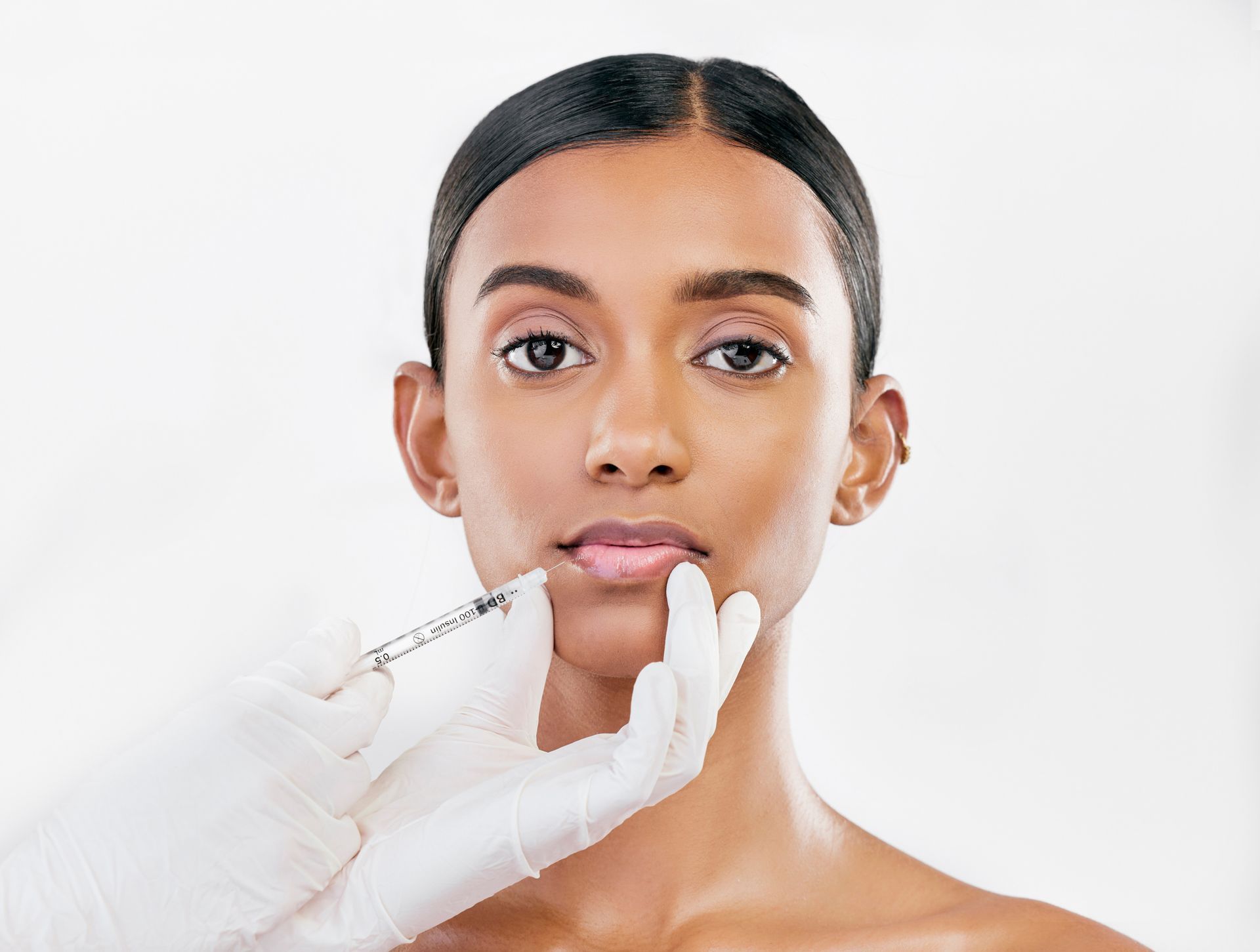 a woman is getting a botox injection in her lips .