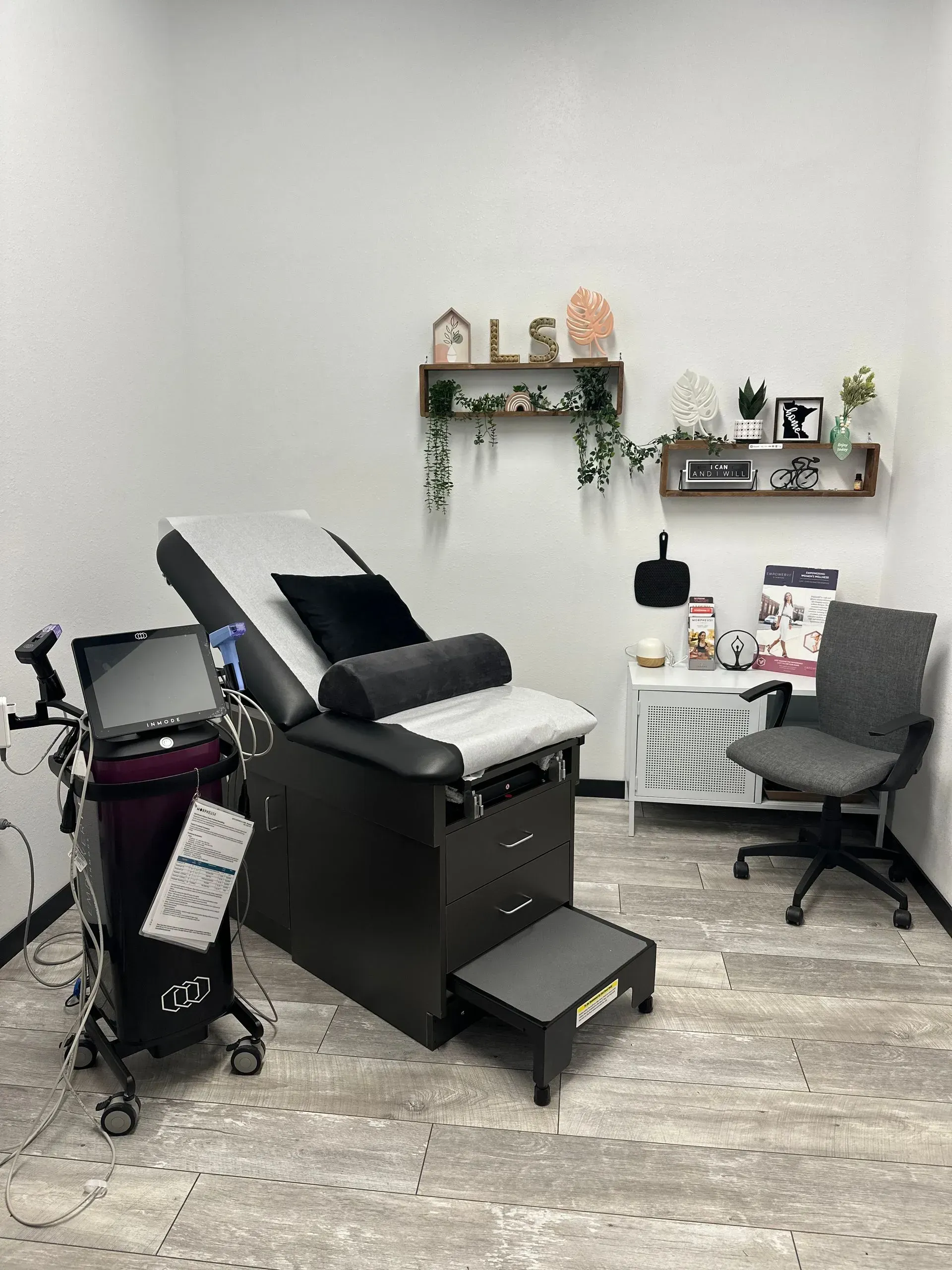 A doctor 's office with a gynecological chair and a chair.