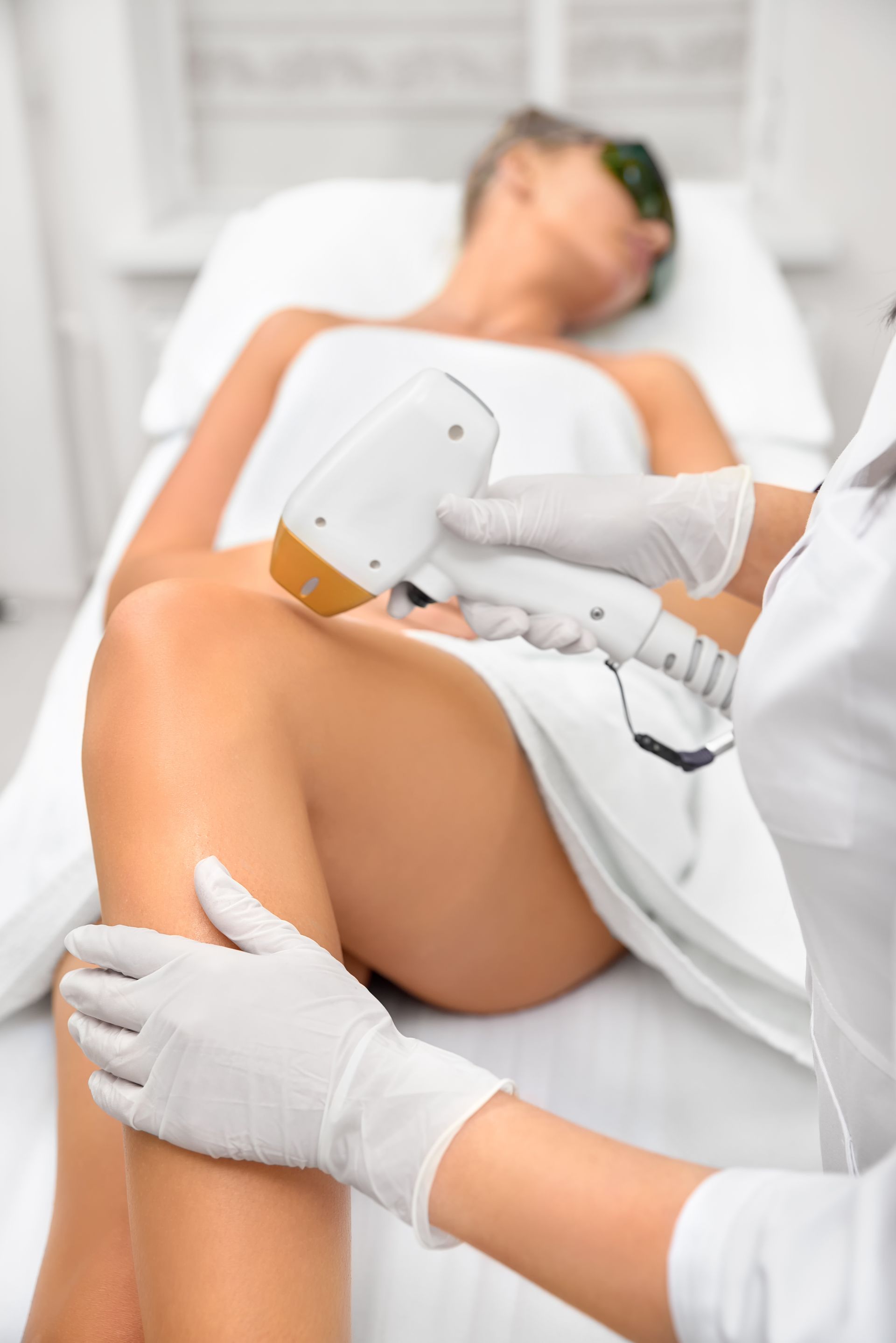 a woman is getting a laser hair removal treatment on her legs .
