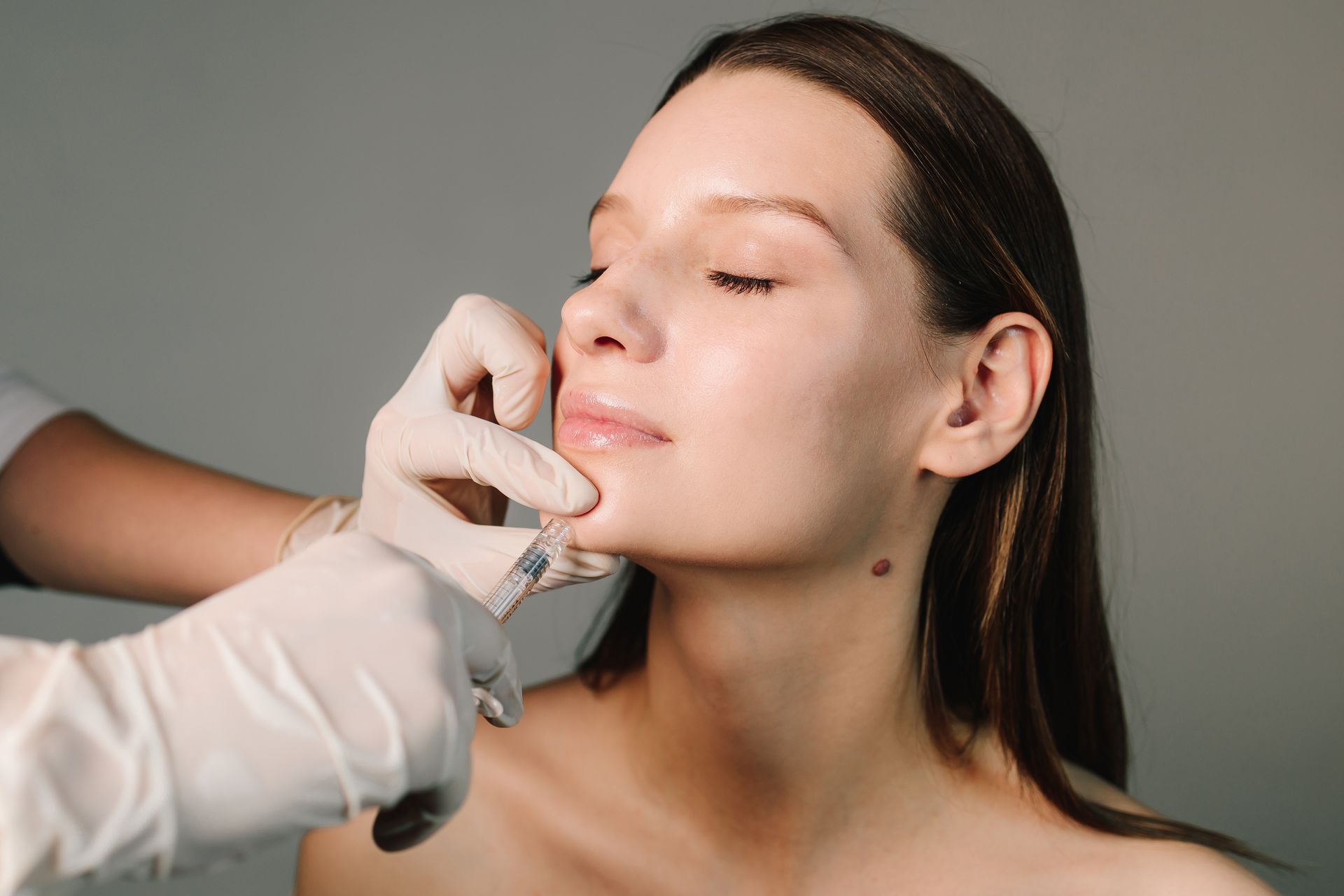 A woman is getting a botox injection in her face.
