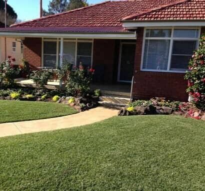 A Brick House With A Lush Green Lawn In Front Of It — Barron River Lawns In Biboohra, QLD