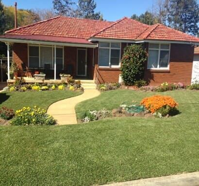 A Brick House With A Red Tile Roof And A Walkway Leading To It — Barron River Lawns In Biboohra, QLD