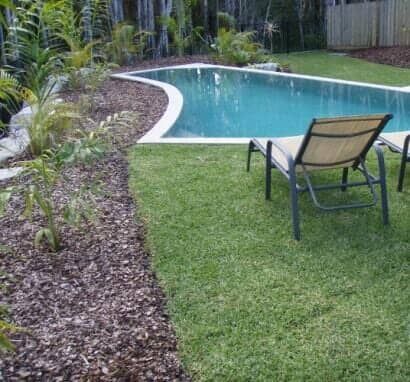 A Swimming Pool Is Surrounded By Lawn Chairs And A Fence — Barron River Lawns In Biboohra, QLD