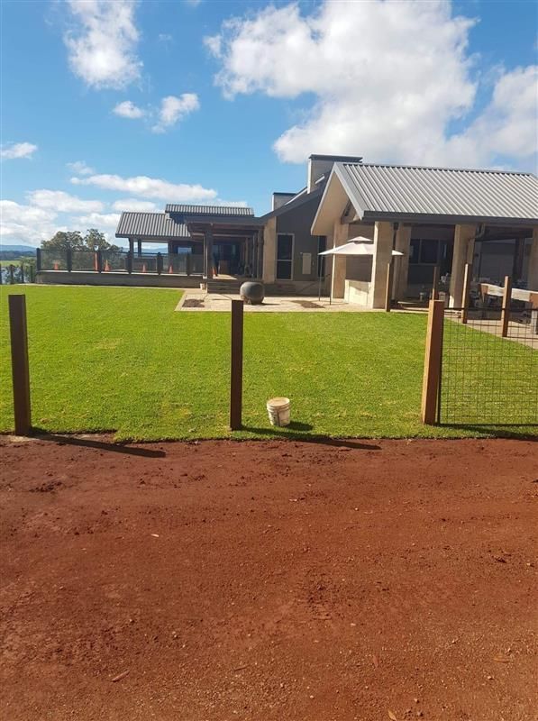 A Large House With A Fence In Front Of It — Barron River Lawns In Biboohra, QLD