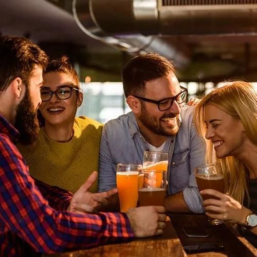 A Group of People Are Sitting at a Table Drinking Beer — Capricorn Tavern in Taranganba, QLD