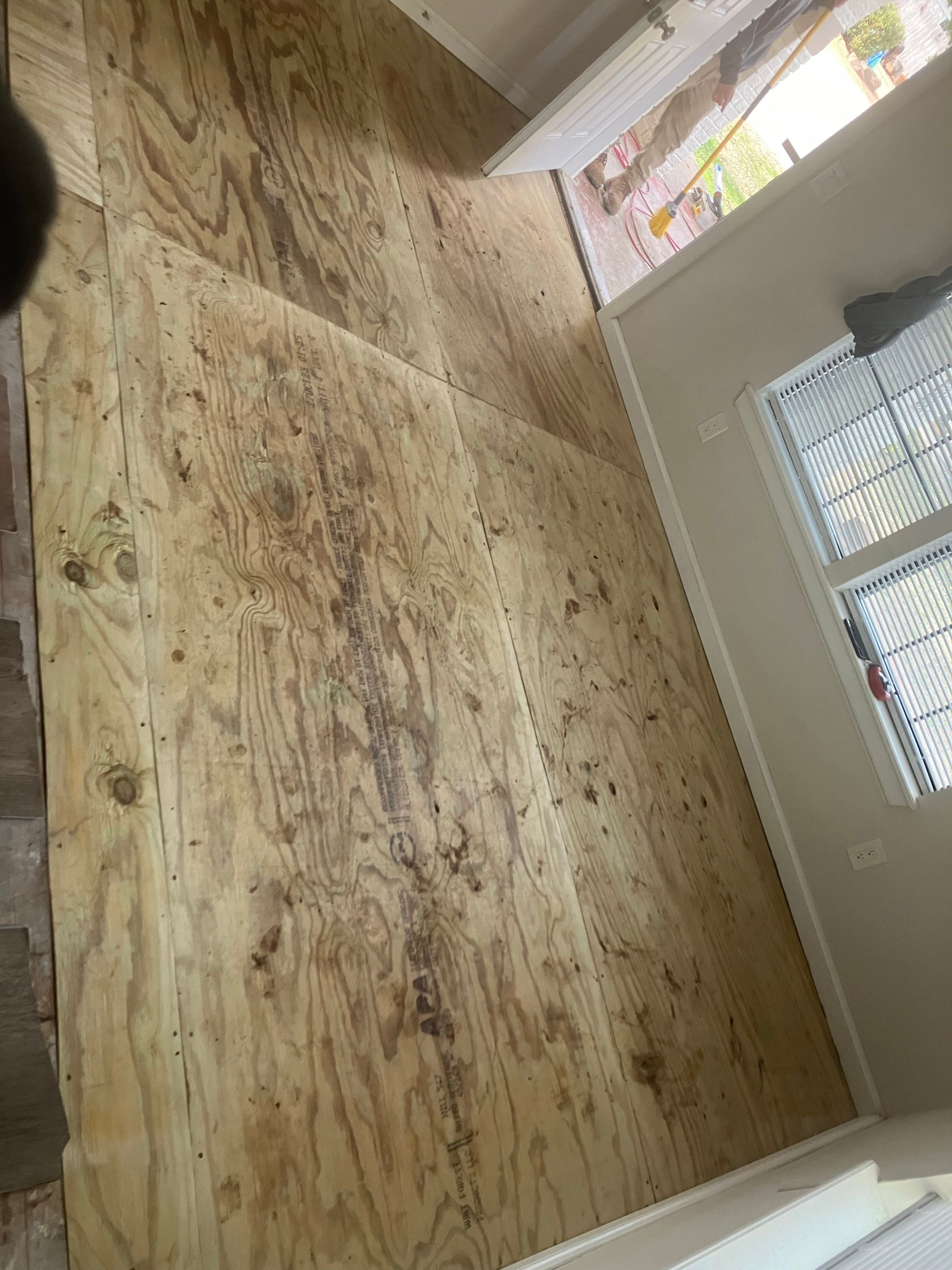 A person is standing on a wooden floor in a room.