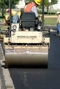 A contractor performing an asphalt overlay in Denver, CO