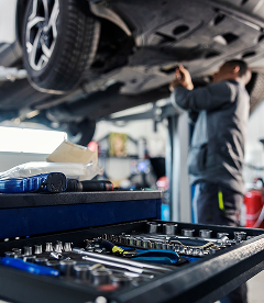 Our Technician Works on a Lifted Vehicle in Houston, TX | Exclusive Collision And Customs