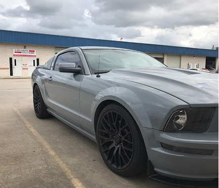 Gray Ford Mustang Parked in Parking Lot in Front of Our Collision Center in Houston, TX | Exclusive Collision And Customs