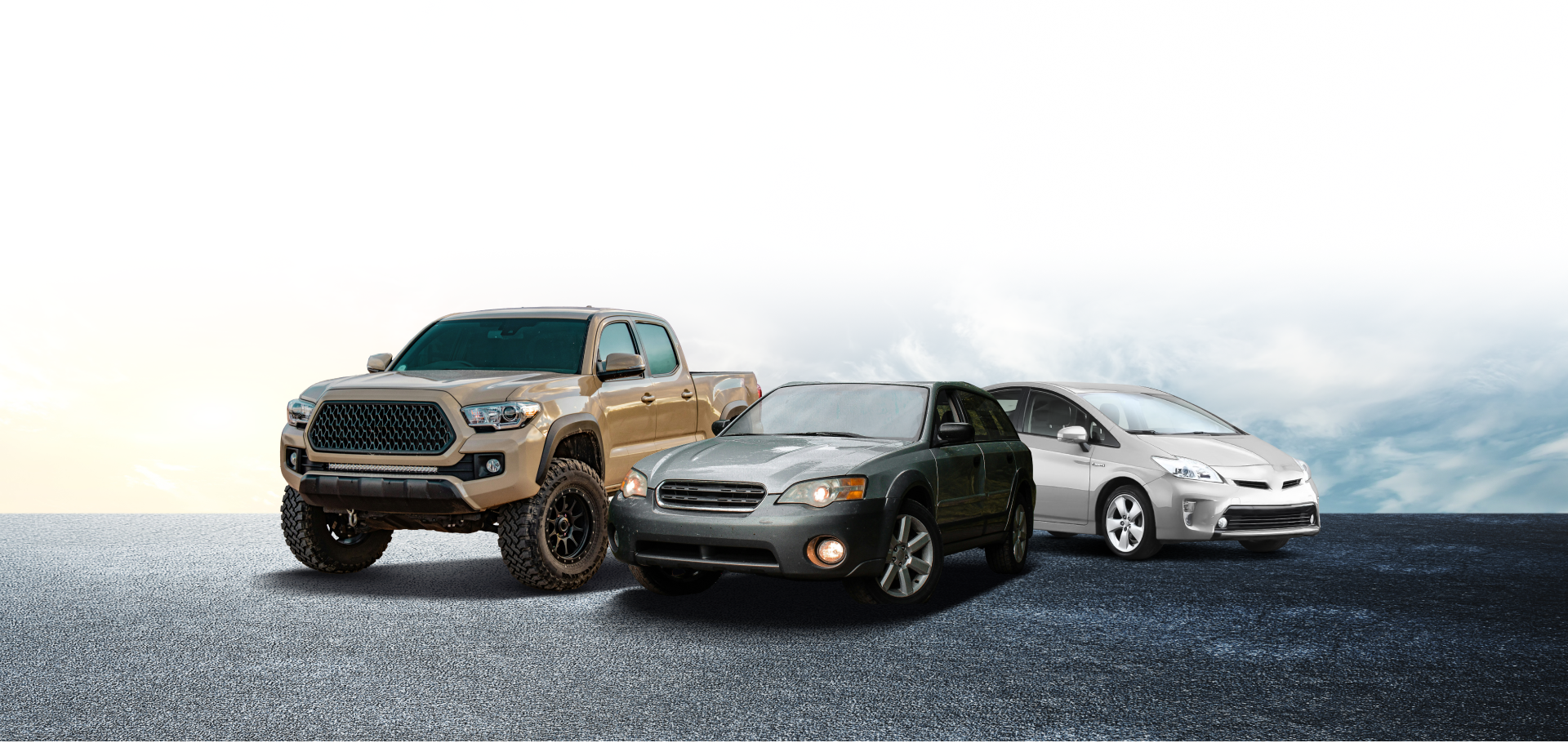 Three vehicles: a beige truck, gray sedan, and silver hybrid on a dark asphalt surface with a cloudy sky background | Exclusive Collision And Customs