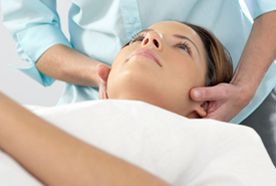 A therapist with hands on a lady's head
