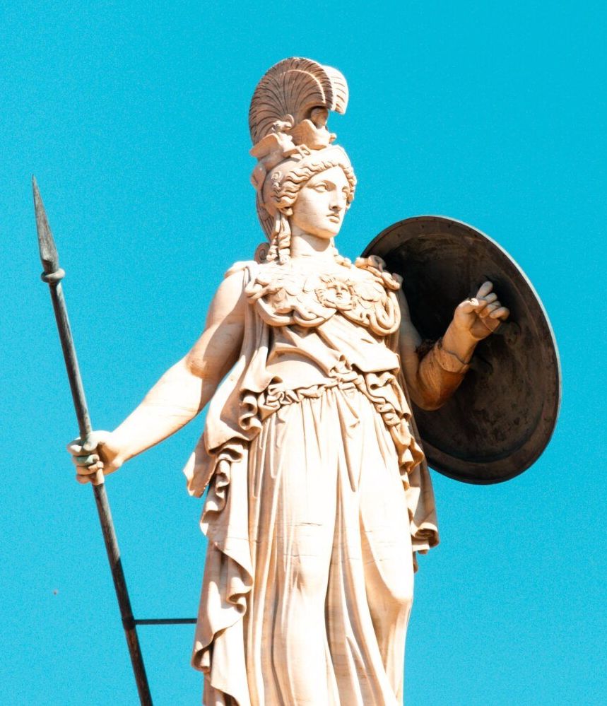 Greek statue holding spear and shield.