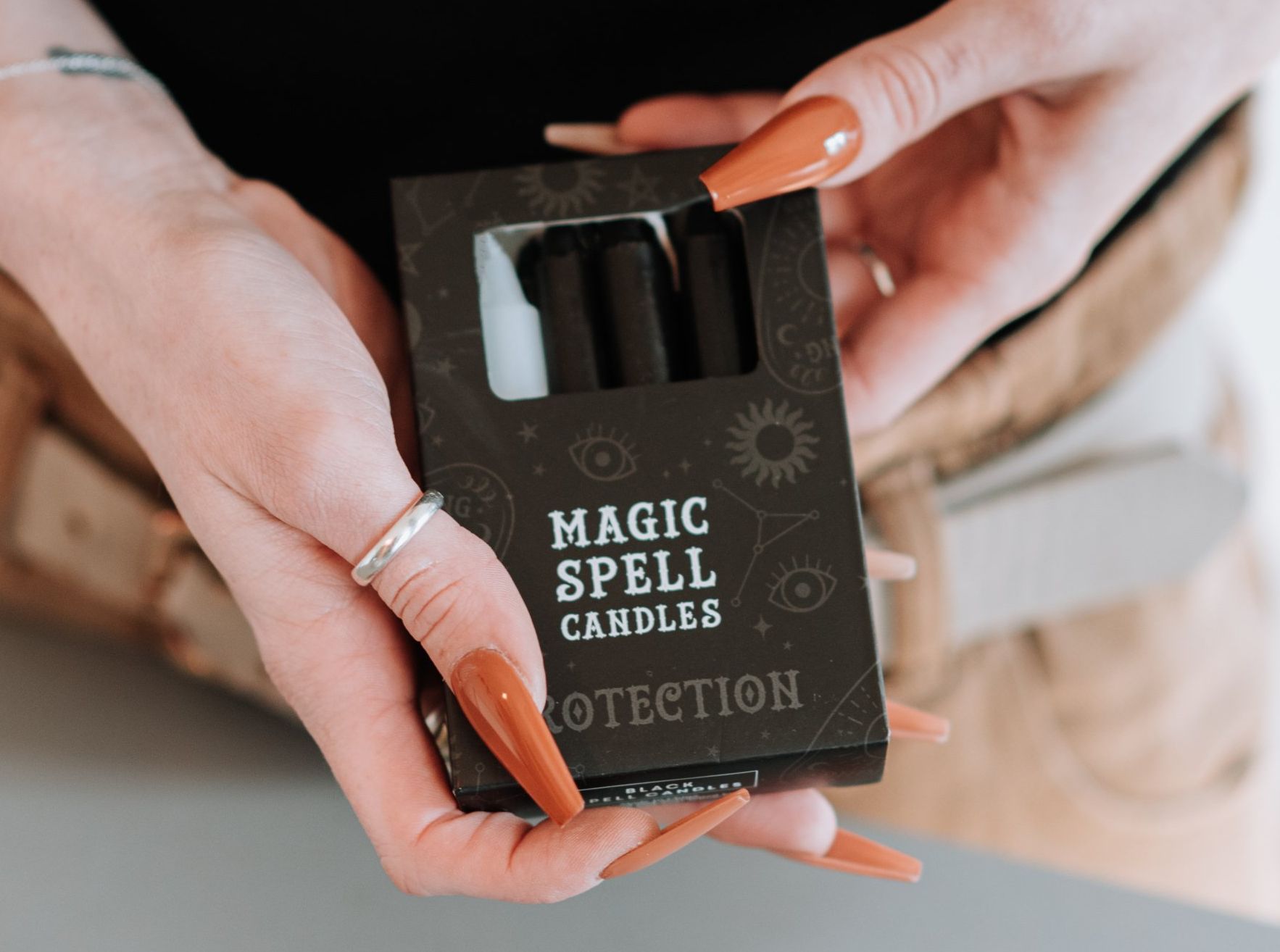 a woman is holding a box of magic spell candles for protection.