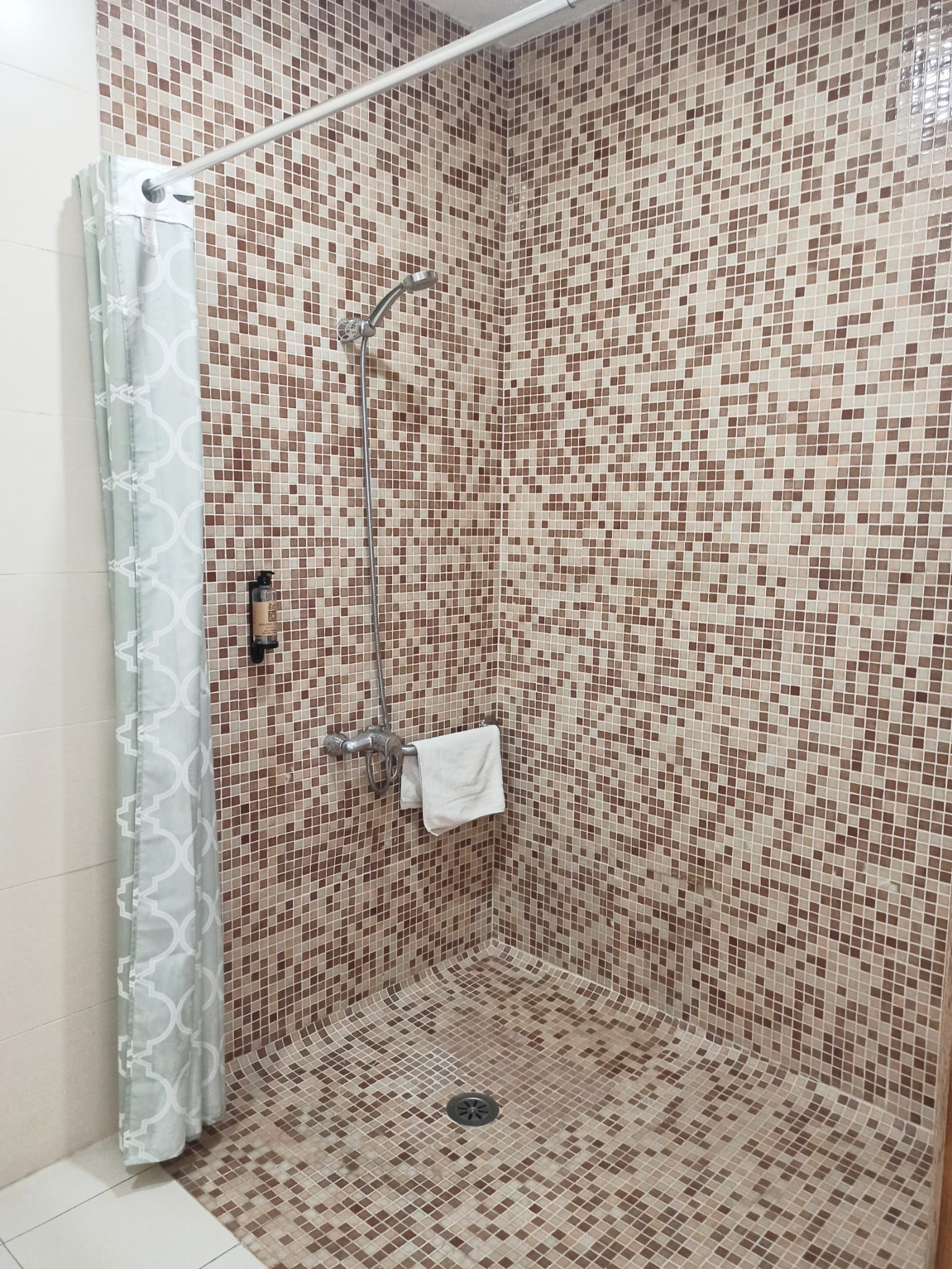 A bathroom with a walk in shower and a shower curtain.