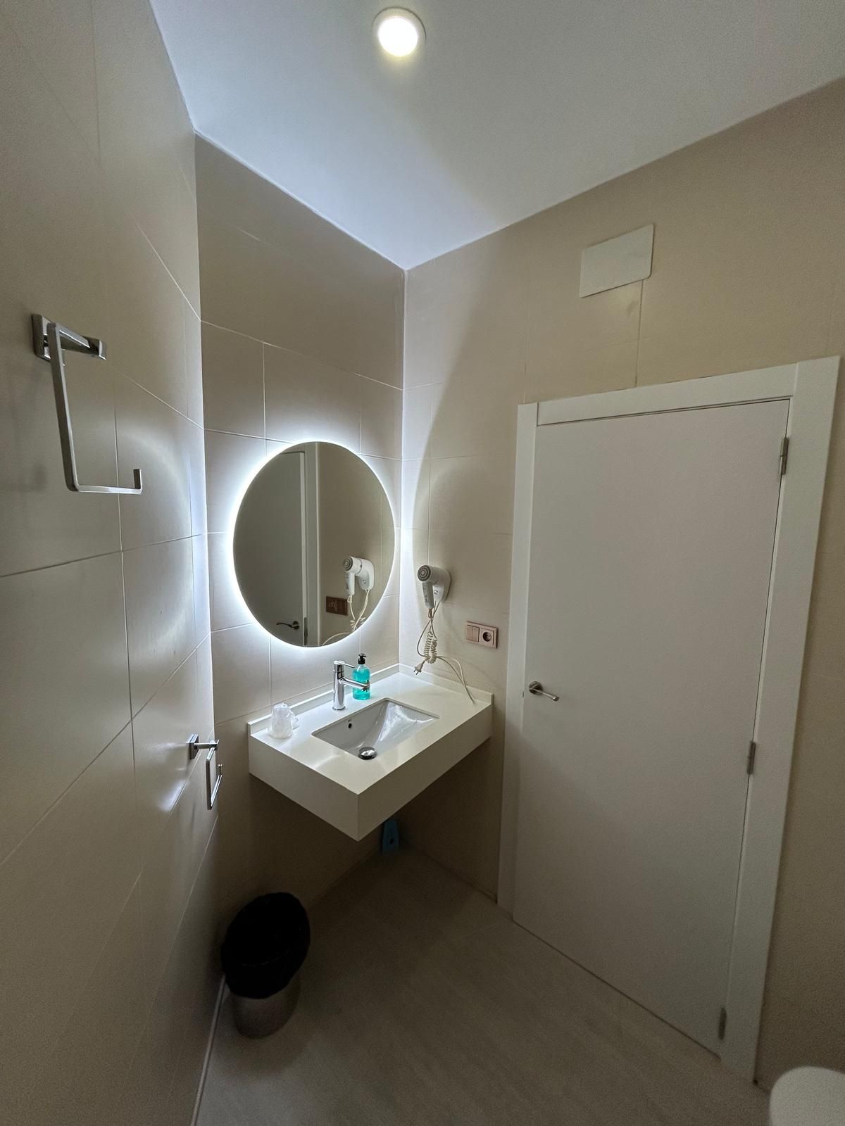 A bathroom with a sink , mirror and toilet.