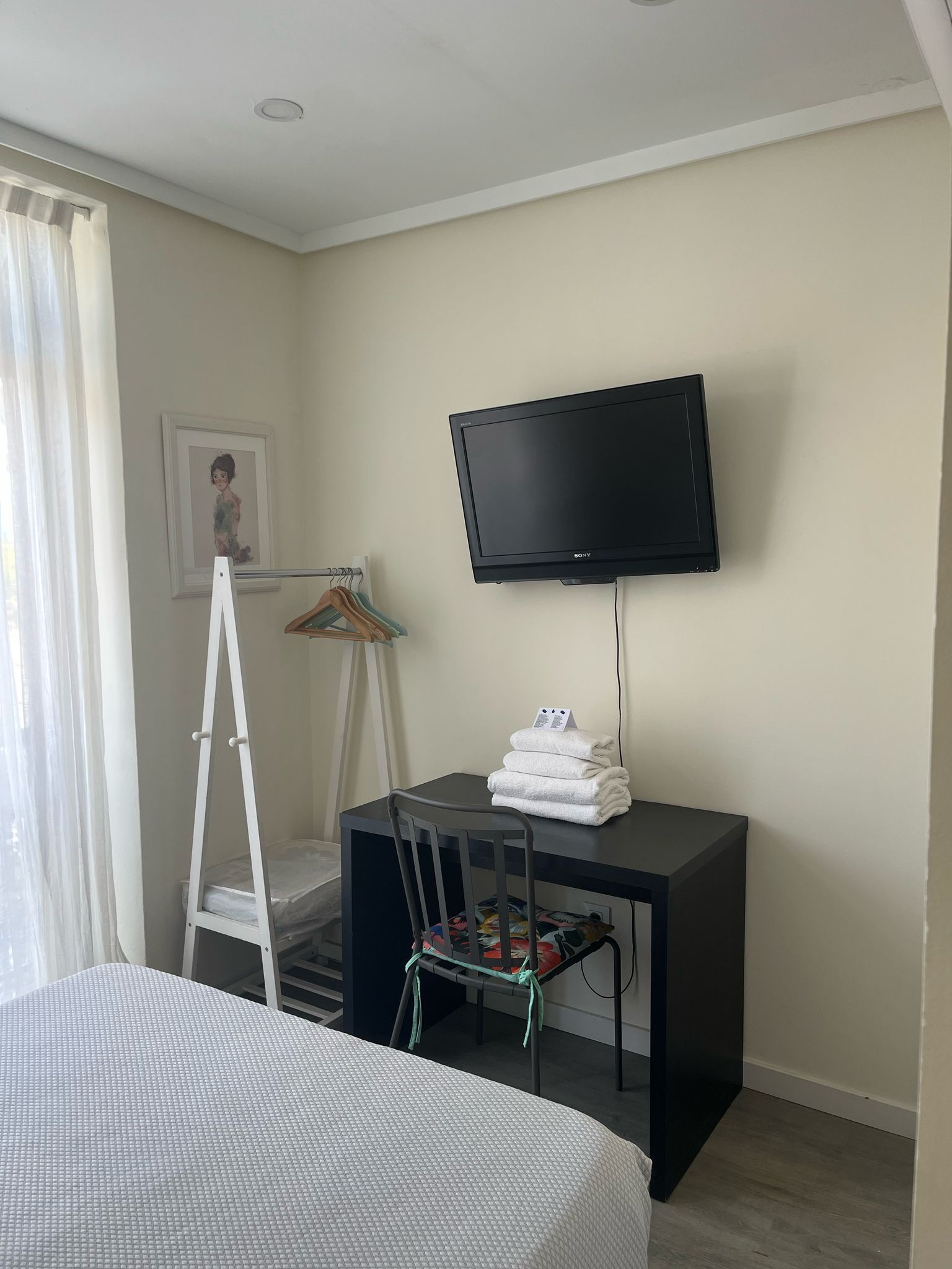 A bedroom with a bed , desk , chair and television.