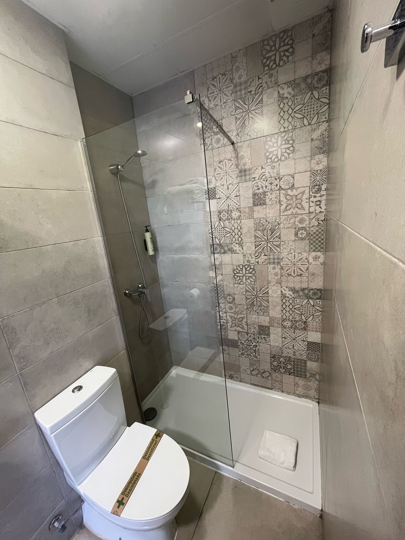 A bathroom with a toilet , shower and walk in shower.