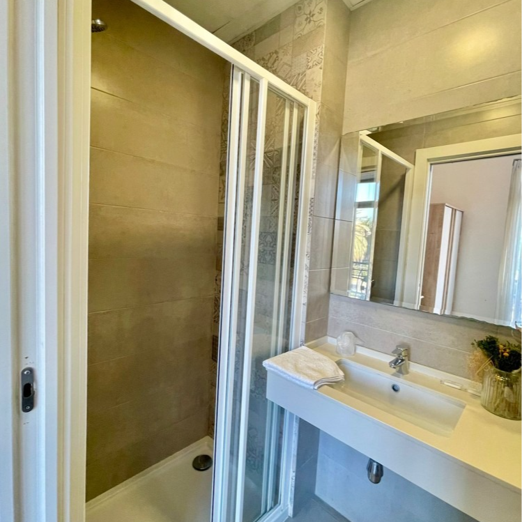 A bathroom with a sink and a shower stall