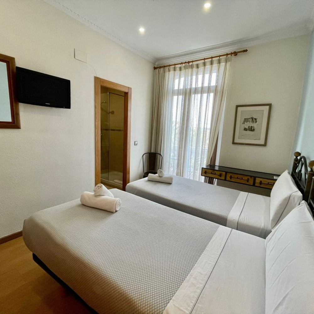 A hotel room with two beds and a television