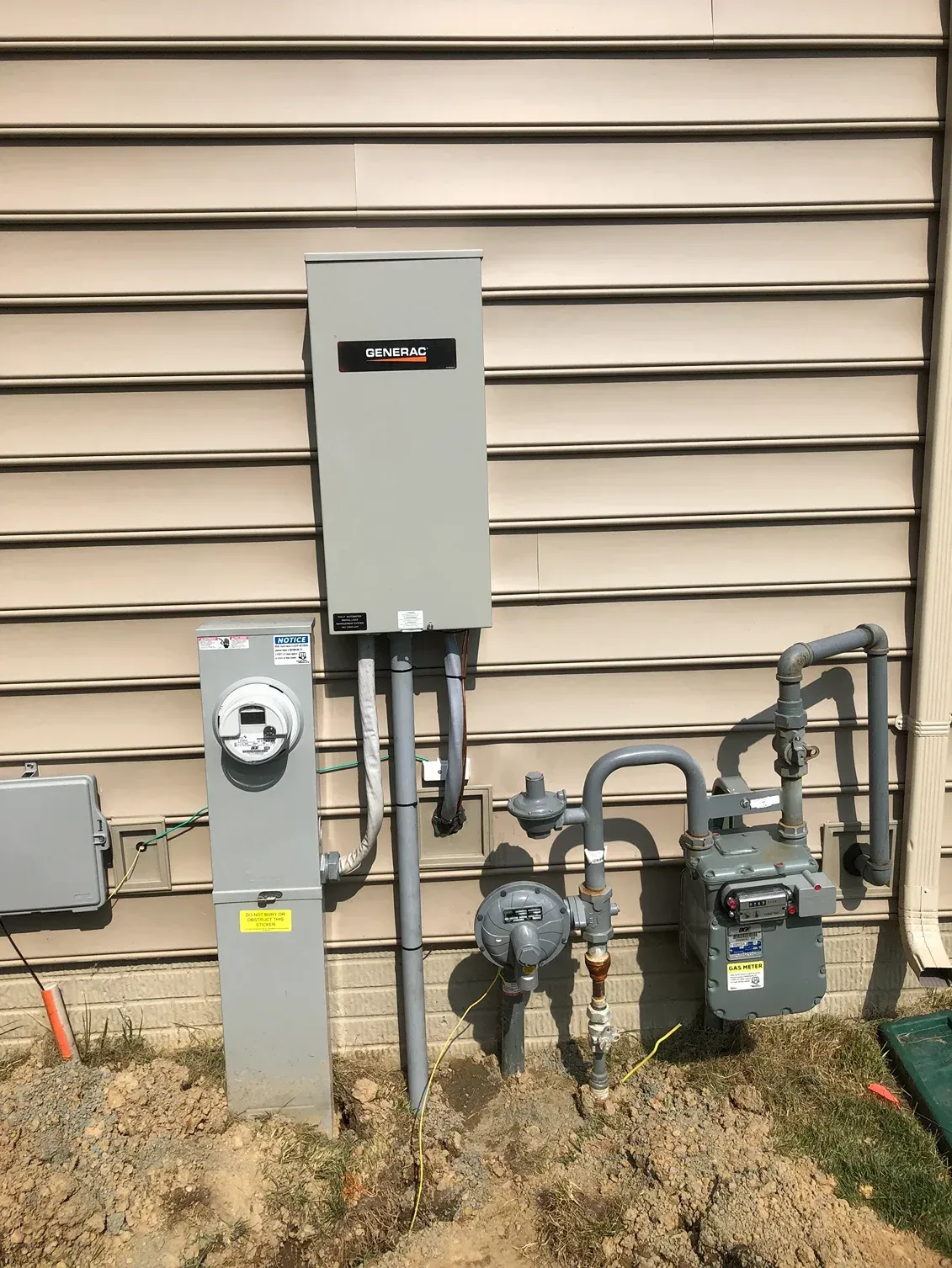 Outdoor gas and electrical meter equipment mounted on a beige house exterior